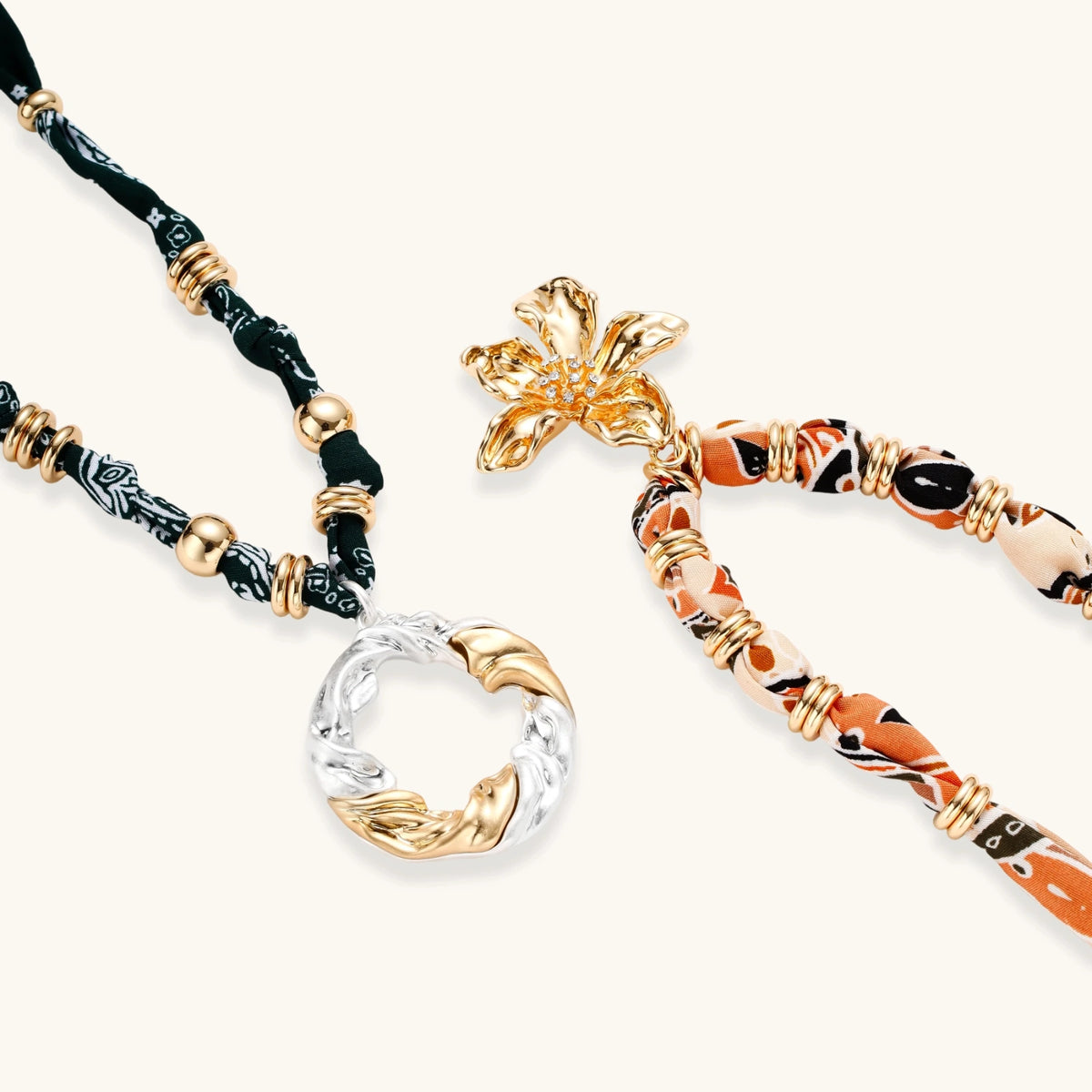 Vibrant patterned fabric necklace with gold-toned flower pendant featuring rhinestone center on white background